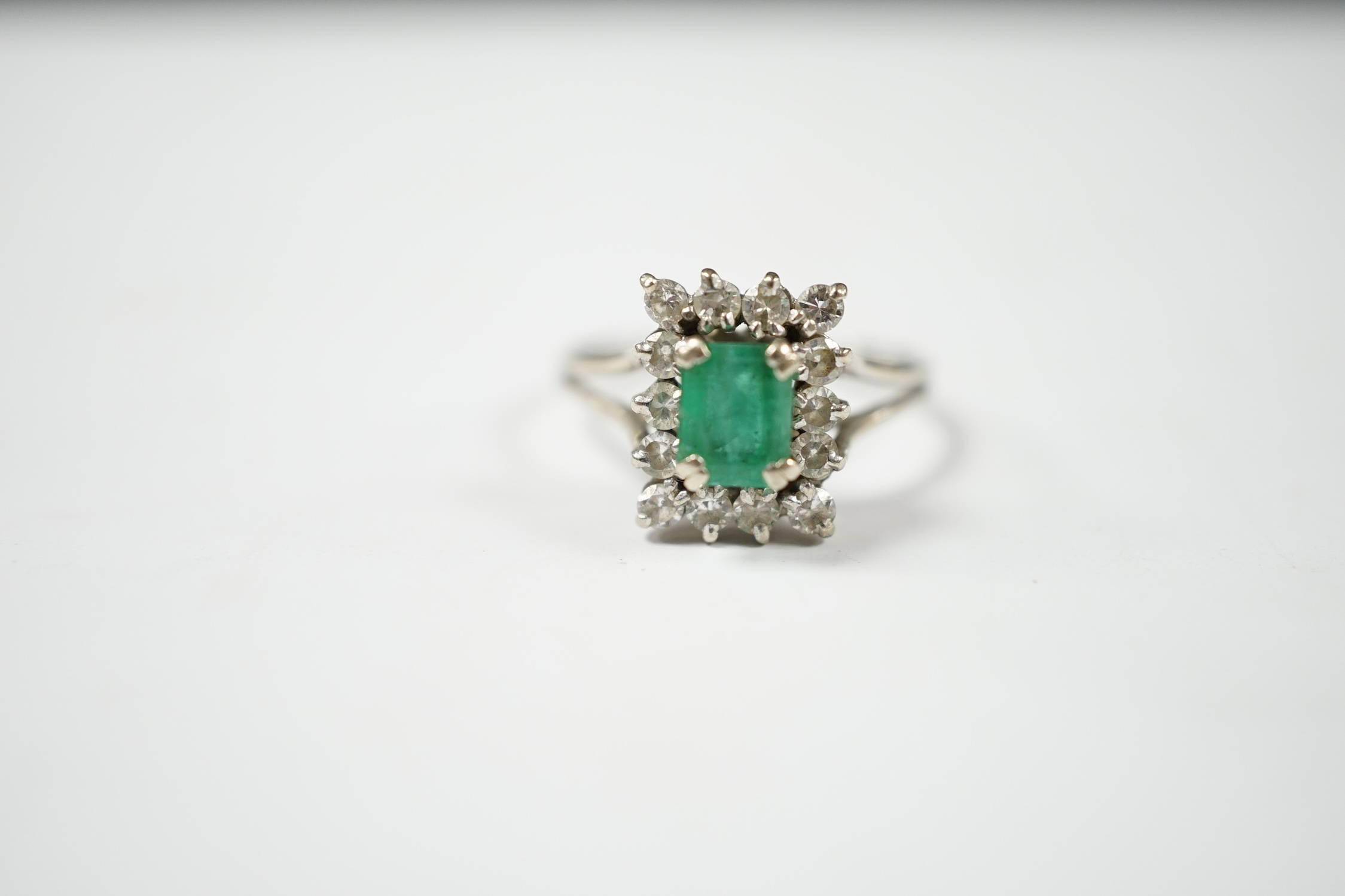 A 1960's white gold?, emerald and diamond set rectangular cluster ring, size T/S, gross weight 4.3 grams. Condition - poor